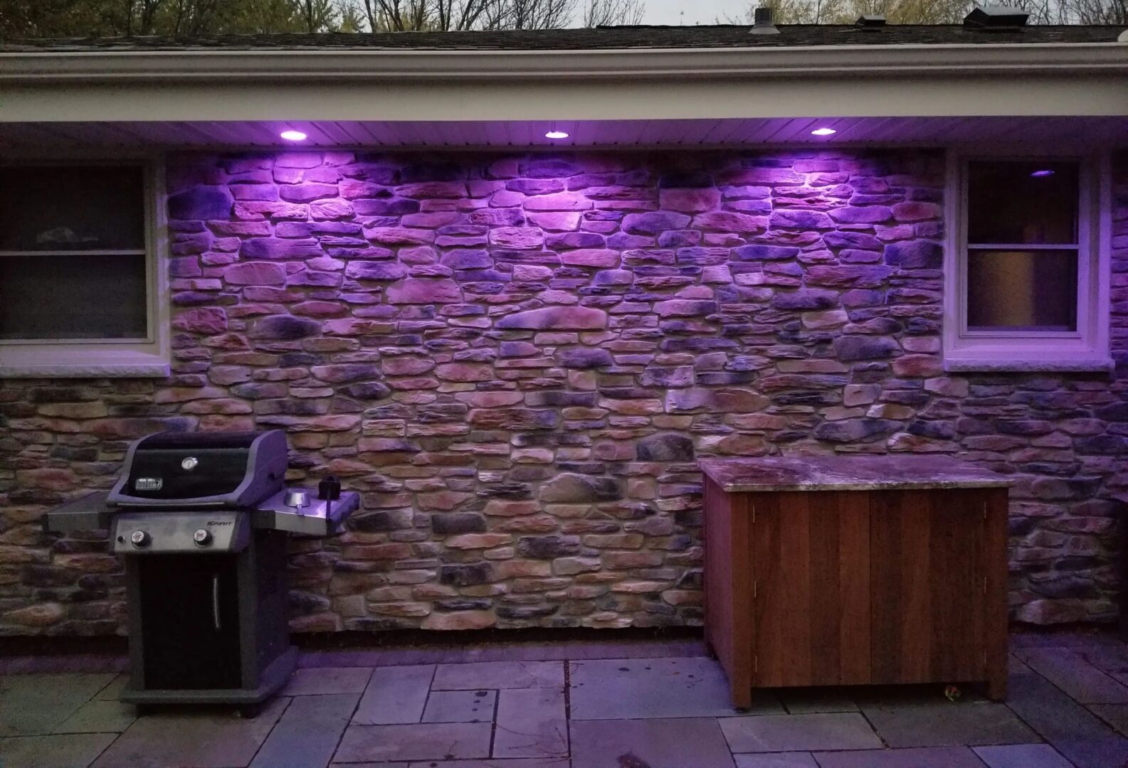 A Stone Wall With Lights In Violet Color