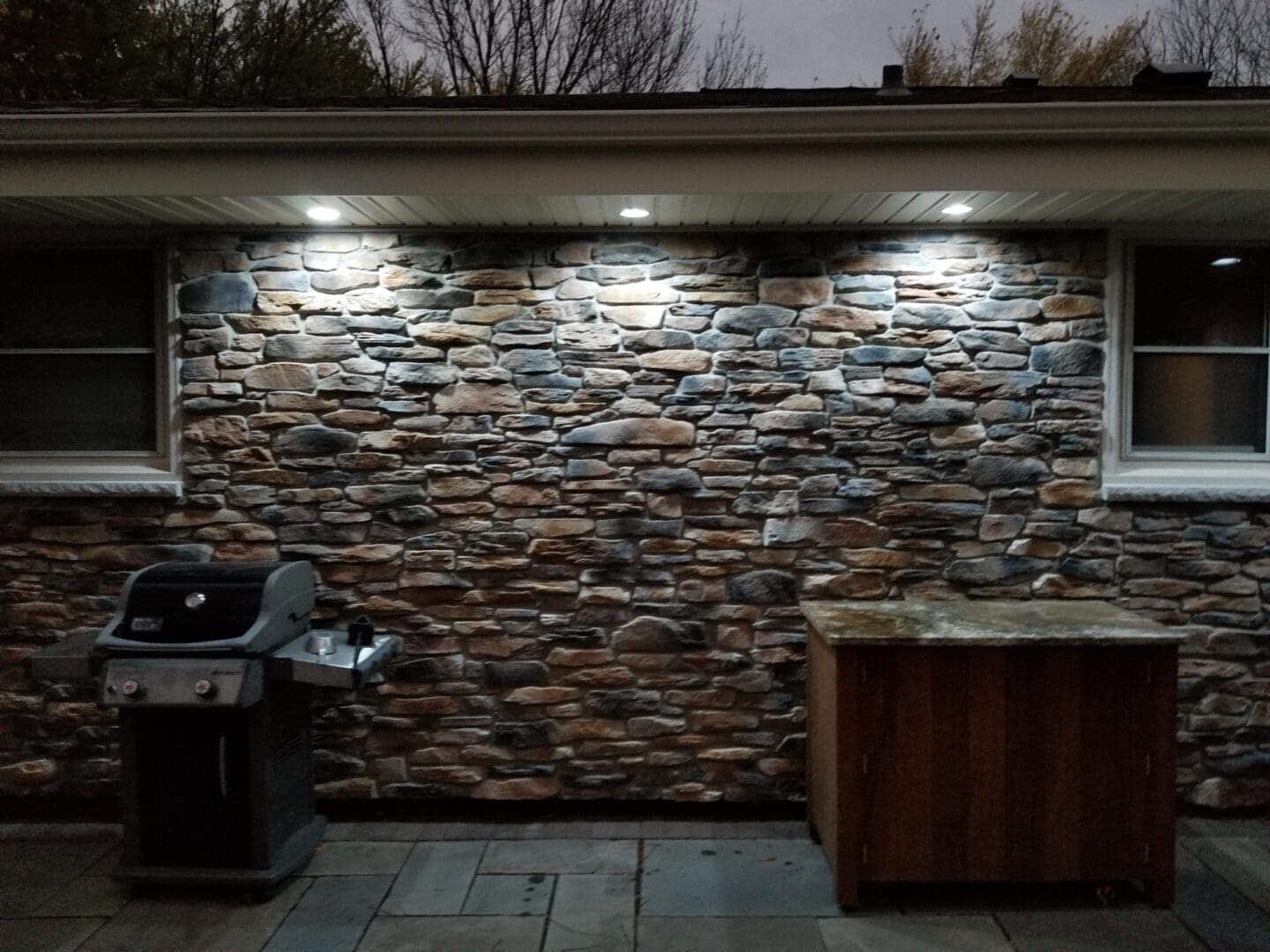 A stone wall with lights on the side of it